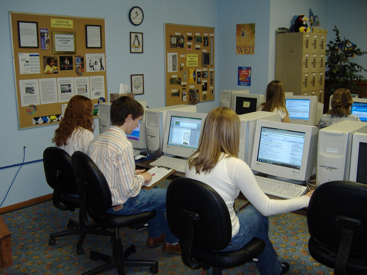 Students seated at desktop computers while working on a classroom assignment.